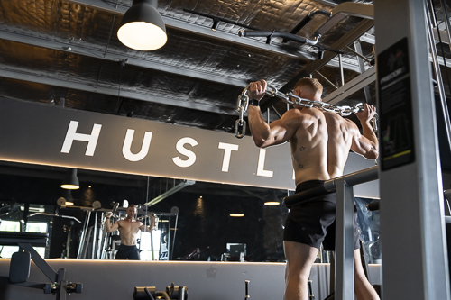 Levi Cox doing a chin-up on a chain handle, Hustle gym